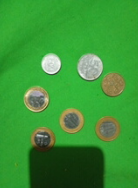 Moedas antigas, e moedas de 1real com o fundo diferente.